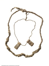 Zwei hieratische Papyrusstreifen, als Amulett gefaltet an einer Bastschnur