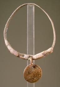 Armring, in zwei Hundeköpfe ausgehend, in deren Maul zwei Münzen hingen (eine ist erhalten: Tiberius 34 n. Chr.)