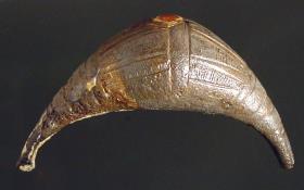 Fibel mit vollem, geschlossenem, geschwelltem Bügel; gravierte Streifen und konzentrische Kreise auf dem ... Bügel; Nadel fehlt; an den Bügel festgerostet ein Ring mit gravierten Linien