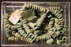 Große Kette aus kleinen runden Ringen, die zum Teil noch auf dem antiken Faden gereiht sind. Ein Teil modern aufgereiht