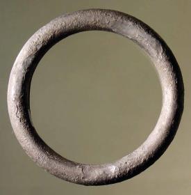 Armband von ovalem Querschnitt, vollständig geschlossen; aus einem Blechstreifen zusammengebogen und innen hohl; die Naht läuft auf der Innenseite entlang