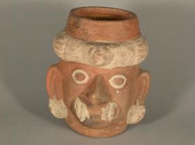 Anthropo-zoomorpher Kopf mit Felidenzähnen