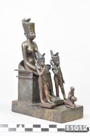 Figurengruppe mit der thronenden Neith und vor sich zwei Horusknaben sowie den Stifter