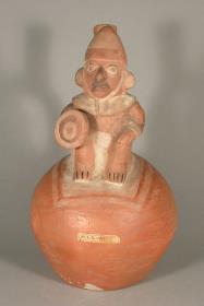 Applikation: sitzende anthropomorphe Figur mit Schild