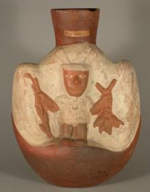 Relief: stehende anthropomorphe Figur mit Kulturpflanzen