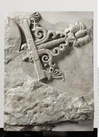 Brüstungsrelief (Waffenrelief) der Hallen des Athenaheiligtums in Pergamon. Waffenrelief - rechte Teil einer vollständigen, aus zwei Platten bestehenden Brüstungsplatte: abgearbeiteter Schiffsschnabel, Schiffszeichen (Oberteil) mit pflänzlichem Dekor