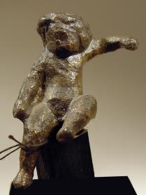 Statuette eines sitzenden nackten Knaben
