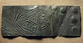 Fragment eines starken Blechs. Als Verzierung dient eine Sphinx, von der nur der Kopf und der Flügel erhalten ist. ...