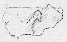 Kleines Fragment eines Blechs. Von der Darstellung erhalten ein Teil einer sitzenden Sphinx (?)