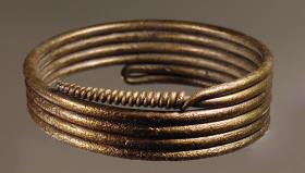 Armring: sechsfach gewickelter Draht, das Ende spiralförmig um letzte Windung gelegt