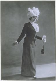 Renée Desprez in Bluse, Rock und Jacke von Brenner