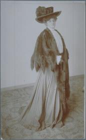 Frau in Bluse, Rock und Cape