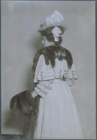 Frau in Kleid und Pelzstola mit Muff