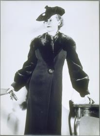 Frau in Mantel von Lydia Voll und mit Kappe von Hilde Rossins