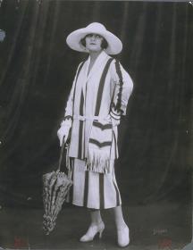Lya de Putti in Jacke und Rock mit Hut von Modellhaus Max Becker