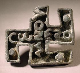 Hakenkreuzförmiger Stempel mit griechischer Inschrift: COΖΕΖΟ / ΜΝΟΥ