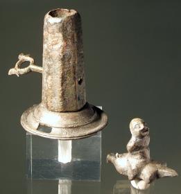 "Kleiner Brunnen, der vielleicht als Kinderspielzeug diente", dazu auch die Statuette eines auf einem Weinschlauch reitenden Schauspielers (Pasticcio)