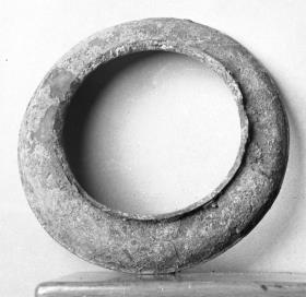 "Ringförmiger Untersatz" (Durch die am Rand erhaltene Attasche in Palmettenform erweist sich das Objekt als Teil eines Siebs)