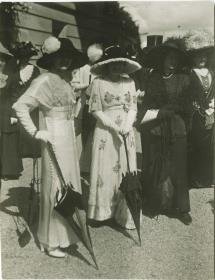 Frauen in Kleidern auf dem Rennplatz
