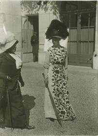 Frau in Kleid und Frau in Kostüm auf dem Rennplatz
