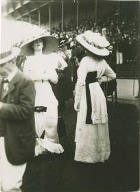 Frauen in Kleidern auf dem Rennplatz