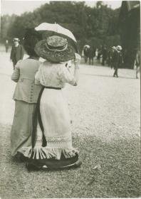 Frau in Kleid und Frau in Kostüm auf dem Rennplatz