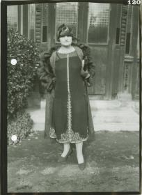 Frau in Kleid und Mantel auf dem Rennplatz
