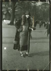 Frau in Kleid und Mantel auf dem Rennplatz