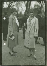 Frauen in Mänteln auf dem Rennplatz