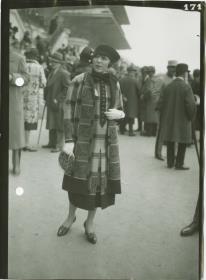 Frau in Mantel auf dem Rennplatz