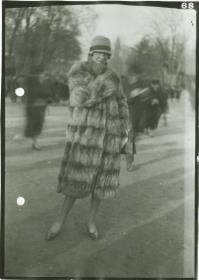 Frau in Mantel auf dem Rennplatz