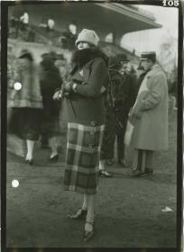 Frau in Mantel auf dem Rennplatz