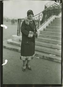 Frau in Mantel auf dem Rennplatz