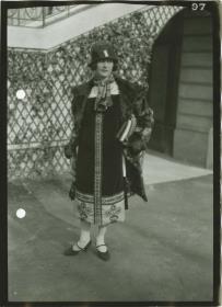 Frau in Kleid und Mantel auf dem Rennplatz