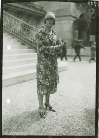 Frau in Kleid und Mantel auf dem Rennplatz in Longchamp