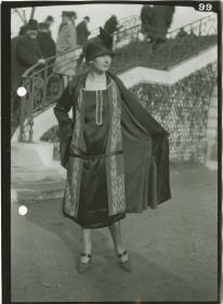 Frau in Kleid und Mantel auf dem Rennplatz