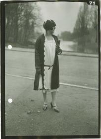 Frau in Kleid und Mantel auf dem Rennplatz