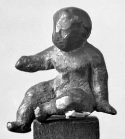 Statuette eines sitzenden nackten Knaben