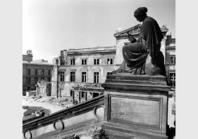 Blick auf die Sandsteinfigur von Karl Adalbert Moser an der Freitreppe der Nationalgalerie vor dem Hintergrund des zum Teil zerstörten Neuen Museums und des Alten Museums