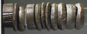 Einer von elf Ringen mit Strichmusterung und zum Teil mit kleinen Kreisornamenten