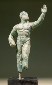 Kleine hellenistische Statuette eines Diskuswerfers, die Linke erhoben, in der Rechten den Diskos, Füße unterhalb des Knies gebrochen