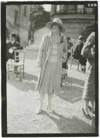 Frau in Kleid und Mantel auf dem Rennplatz in Longchamp
