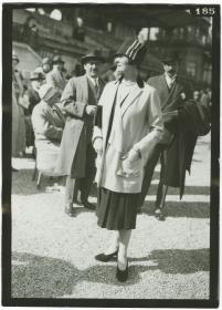 Frau in Kleid und Mantel auf dem Rennplatz in Longchamp