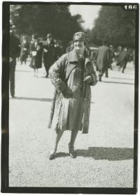 Frau in Kleid und Mantel auf dem Rennplatz in Longchamp