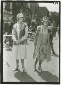 Frau in Kleid und Mantel und Frau in Kleid und Weste auf dem Rennplatz in Deauville
