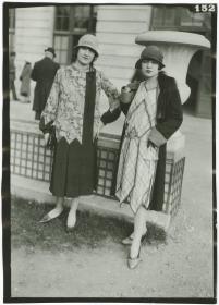 Frau in Kleid und Frau in Kleid und Mantel auf dem Rennplatz in Auteuil