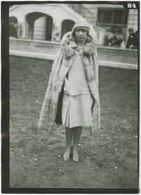 Frau in Kleid und Mantel auf dem Rennplatz in Auteuil