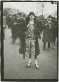 Frau in Kleid und Mantel auf dem Rennplatz in Auteuil