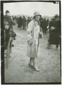Frau in Kleid und Mantel auf dem Rennplatz in Auteuil