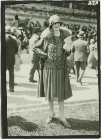 Frau in Kleid und Mantel auf dem Rennplatz in Auteuil